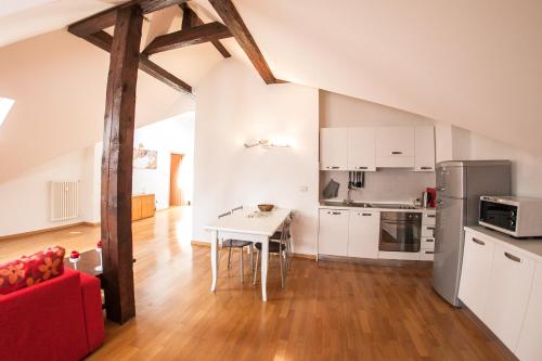 a kitchen with white cabinets and a table in a room at Apartments Villa Anita in Bolzano