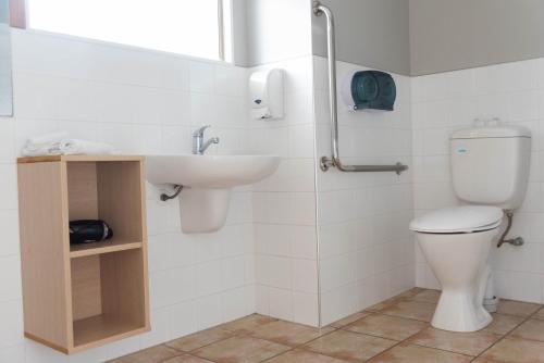 a bathroom with a toilet and a sink at Raglan Sunset Motel and Conference Venue in Raglan