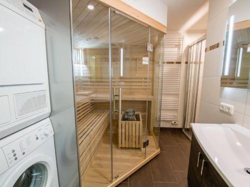 a glass shower in a bathroom with a washing machine at Chalet in Austria near Ski Lift & Sauna in Wald im Pinzgau