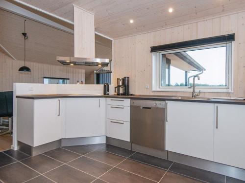 亨能史特蘭德的住宿－8 person holiday home in Henne，厨房配有白色橱柜、水槽和窗户。