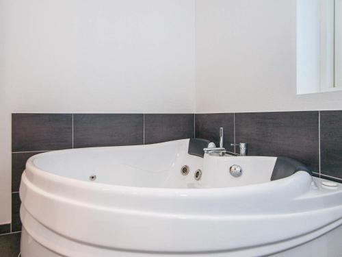 亨能史特蘭德的住宿－8 person holiday home in Henne，浴室设有白色浴缸。