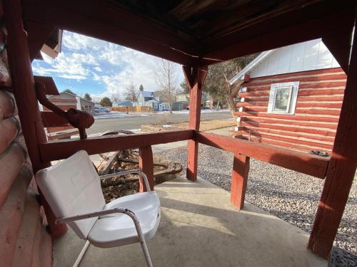 a chair sitting on the porch of a cabin at Roundtop Mountain Vista - Cabins and Motel in Thermopolis