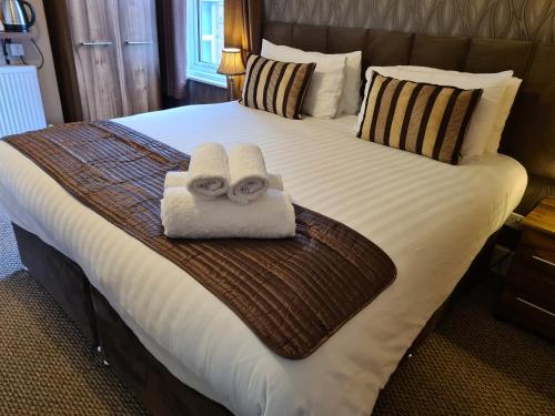 a bedroom with a bed with towels on it at The Penkelie in Southport