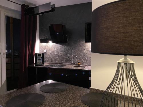 a kitchen with a table with a lamp and a sink at Family & Business Sauna Apartments Klonowa nad Zalewem, Unikat SPA - 2 Bedroom with Private Sauna, Jacuzzi, Air Conditioning, Garage - The Highest Standard! in Kielce