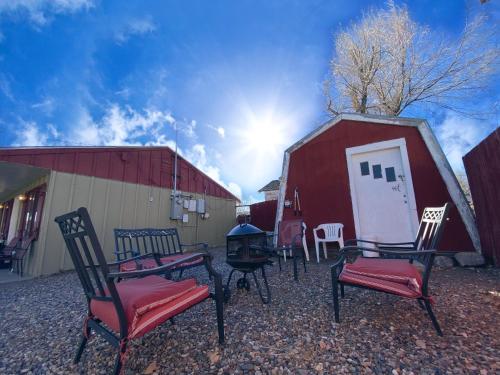 a group of chairs sitting in front of a barn at Roundtop Mountain Vista - Cabins and Motel in Thermopolis