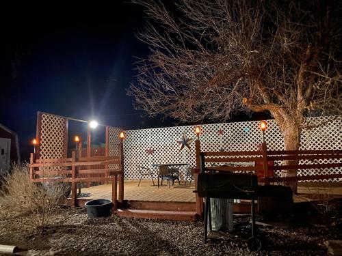 a wooden deck with a table and a tree at night at Roundtop Mountain Vista - Cabins and Motel in Thermopolis