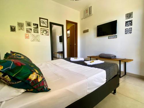 a bedroom with a bed with a table and a television at A Coroa Hostel & Pousada in Arraial do Cabo