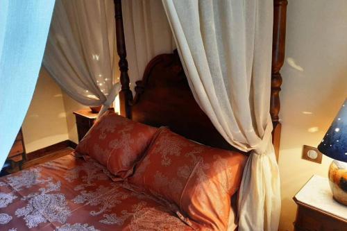 a bedroom with a canopy bed with curtains at MAISON DE NOSTRADAMUS*** OCCITANIE INSOLITE in Alet-les-Bains