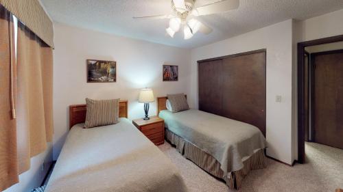 sypialnia z 2 łóżkami i wentylatorem sufitowym w obiekcie Pines at Meadow Ridge w mieście Fraser