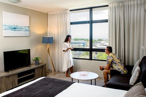 a woman standing in a hotel room with a man at Alivio Hotel Cairns in Cairns