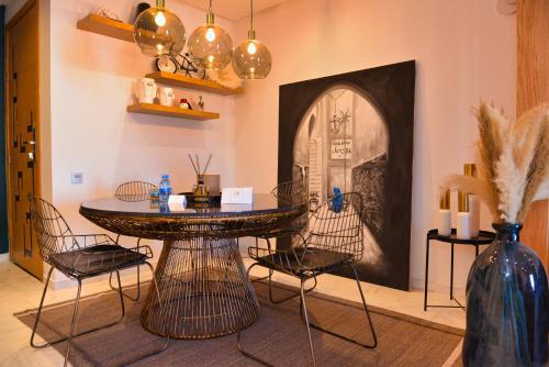 a room with a table and chairs and a vase at Appartement de prestige climatisé à l'hivernage 400m de la Gare in Marrakech