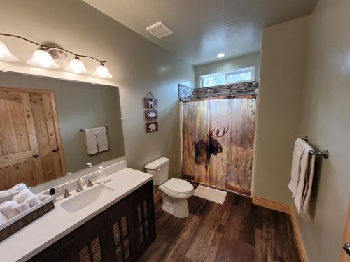 a bathroom with a toilet and a shower with a deer shower curtain at East Zion Trails Retreat-Hot tub, Resort Amenities, Exceptional in Orderville