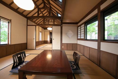 a dining room with a wooden table and chairs at Ryokan Fukinoya in Yufuin
