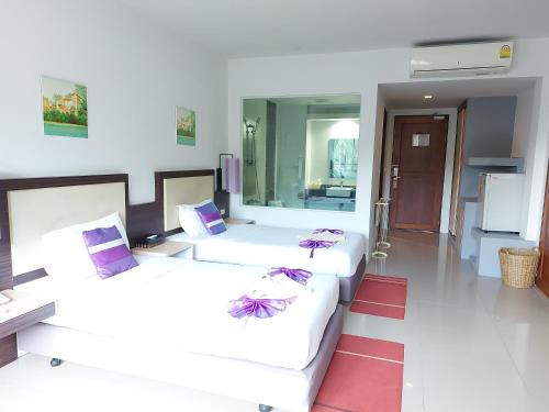 a living room with two beds and a couch at AM Surin Place - SHA Extra Plus in Surin Beach