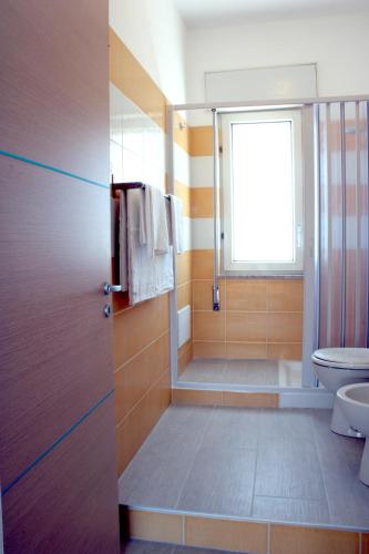 un bagno con doccia, WC e finestra di Case Playa a Balestrate