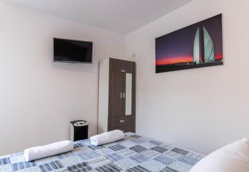 a bedroom with a bed and a tv on the wall at Nakua Paracas Lodge in Paracas