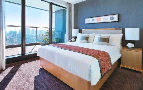 a hotel room with a large bed and a large window at Oakwood Premier Tokyo in Tokyo