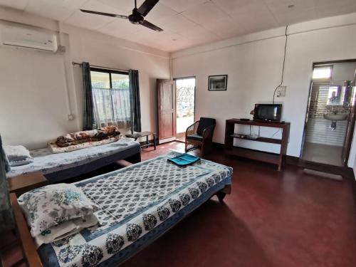 Cette chambre comprend 2 lits et une télévision. dans l'établissement Bhaskar Homestay, à Dibrugarh