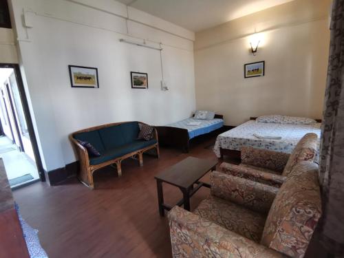 a living room with a couch and a bed at Bhaskar Homestay in Dibrugarh