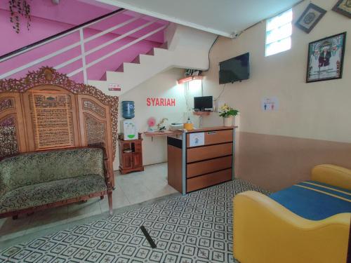 a room with a bedroom with a bed and a desk at Ayuning Guest House Syariah Semarang Mitra RedDoorz in Semarang