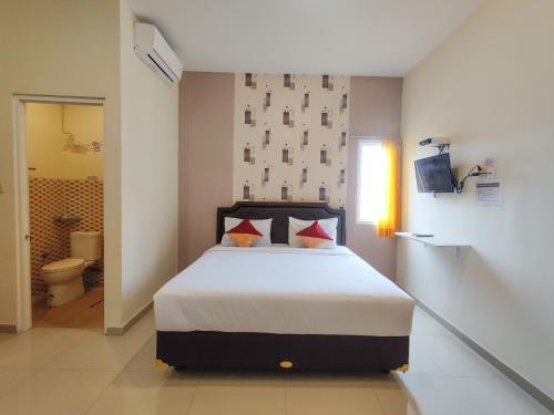 a bedroom with a large bed in a room at Ayuning Guest House Syariah Semarang Mitra RedDoorz in Semarang