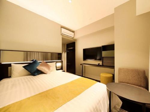 a hotel room with a bed and a table at QuintessaHotel FukuokaTenjin Comic&Books in Fukuoka