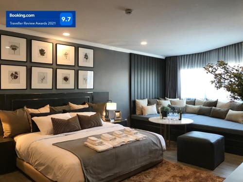 a bedroom with a large bed and a couch at Stay in Style at Nimman R306B in Chiang Mai