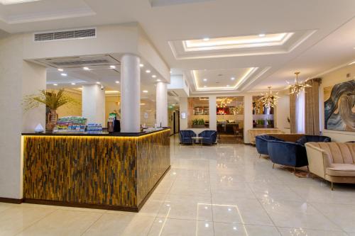 a lobby of a hotel with a reception desk and chairs at Navruz Hotel Tashkent in Tashkent