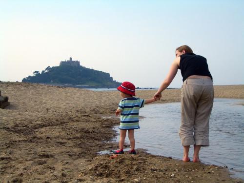 a woman and a child standing on the beach at Marazion Hotel in Marazion