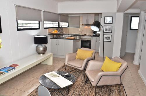 a living room with two chairs and a table at Concord Modern Apartment in Stellenbosch in Stellenbosch