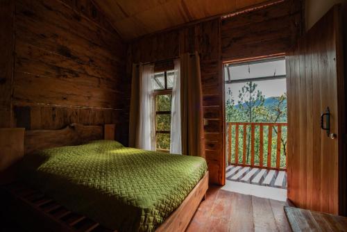 um quarto com uma cama e uma grande janela em Villa Verde em Perquín