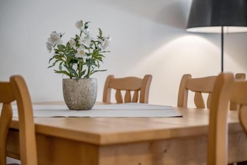 a vase of flowers sitting on a wooden table at Apartment Torri di Seefeld in Seefeld in Tirol