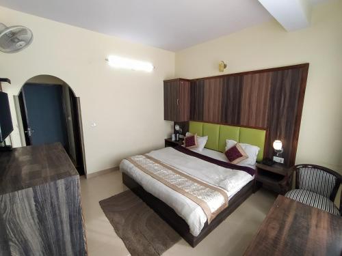 a bedroom with a large bed with a wooden headboard at Hotel The Super Mall Residency, Mussoorie in Mussoorie
