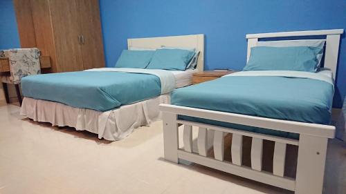 dos camas sentadas una al lado de la otra en una habitación en AlRayani Guest Room, Homestay Kota bharu, en Kota Bharu
