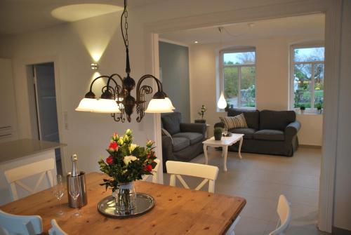 un comedor y una sala de estar con una mesa con flores. en Alte Korbflechterei en Hasselberg