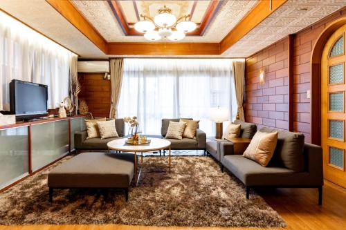 a living room with a couch and a table at Type A Room 120平米 -ウル エスポワール那覇- in Naha
