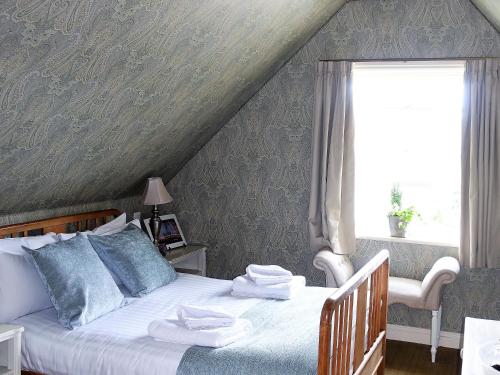 a bedroom with a bed with towels on it at One Holyrood Hotel & Cafe in Newport