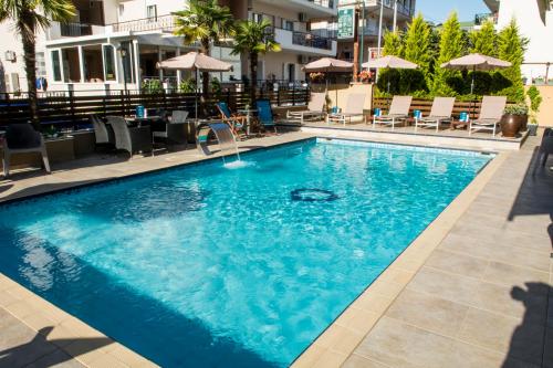 a swimming pool with blue water in a hotel at Olympos Suites Apartments in Leptokaria