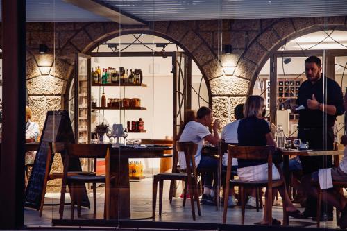 een groep mensen die aan tafel zitten in een restaurant bij Auberge Kallisté - Eco Label in Porto Pollo