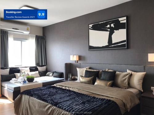 a bedroom with a bed and a couch at Stay in Style, Stay On The Cloud RS504 in Chiang Mai