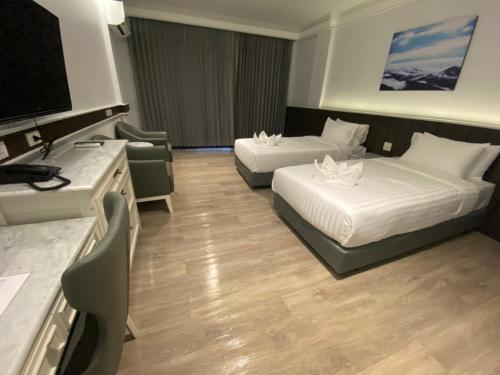 a hotel room with two beds and a flat screen tv at Grandview Landmark Betong Hotel in Betong