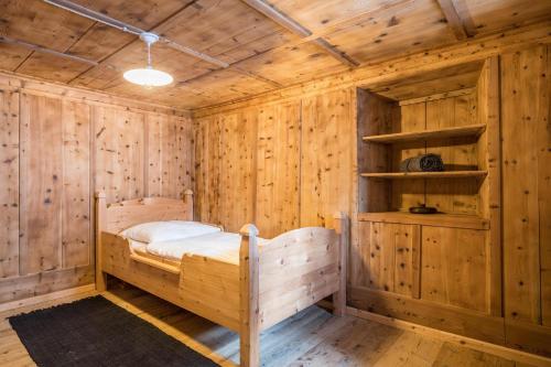 a wooden cabin with a bed in a room at Tannhäuser Mountain Chalet in Predoi