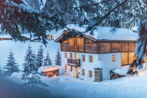 a house in the snow with snow covered trees at Tannhäuser Mountain Chalet in Predoi