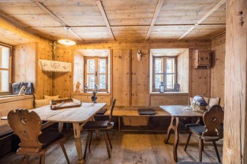 a dining room with a table and chairs and wooden walls at Tannhäuser Mountain Chalet in Predoi
