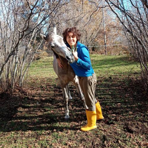 a woman is standing next to a donkey at Agriturismo La Caraffara sull' Etna in Puntalazzo