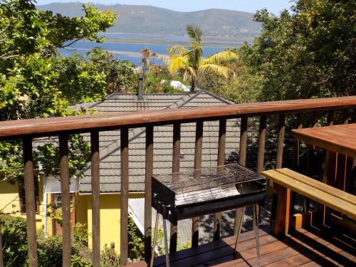 a balcony with a table and a view of the ocean at Protea Guest House in Knysna