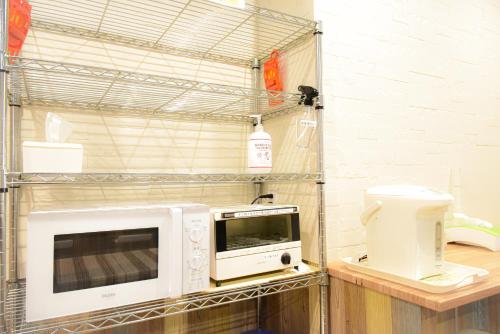 a microwave and a toaster oven on a shelf at Kamata Inn Social in Tokyo