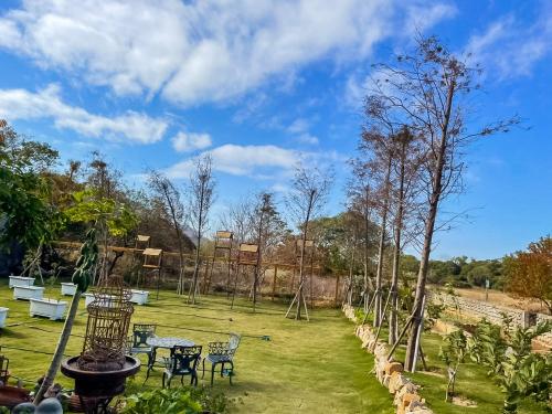 a garden with tables and chairs and a playground at Alice’s Home in Jinsha