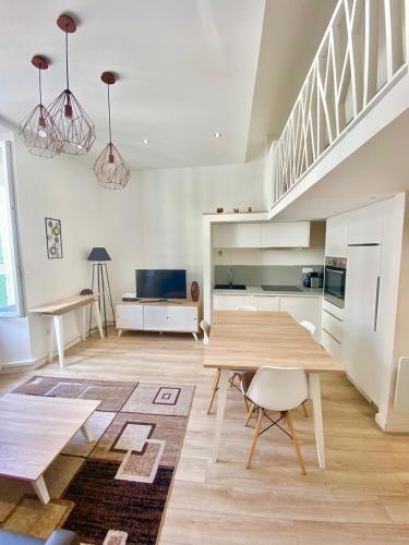 Il comprend un salon avec une table en bois et une cuisine. dans l'établissement Studio La Pietonne-plage-clim, à Menton