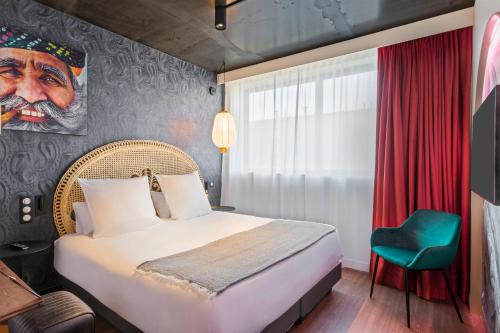 a bedroom with a bed and a painting of a man at Aiden by Best Western Lorient Centre in Lorient
